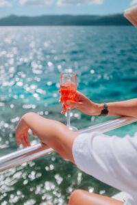 a woman holding a glass of wine on a boat