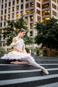 a ballerina sitting on steps in front of a building