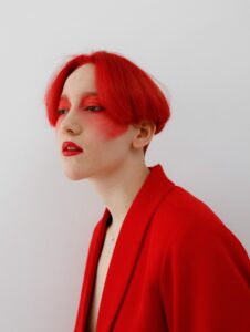 a woman with red hair wearing a red jacket