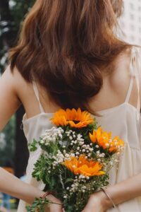 a woman in a white dress holding a bouquet of flowers